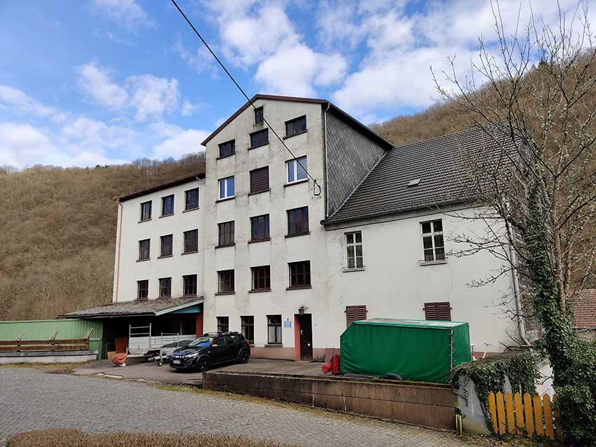 Das Mühlenwohnhaus (rechter Teil) angebaut an die ehemalige Mühle (mittlerer und linker Teil) mit Werkstattbereichen und Lagerflächen.